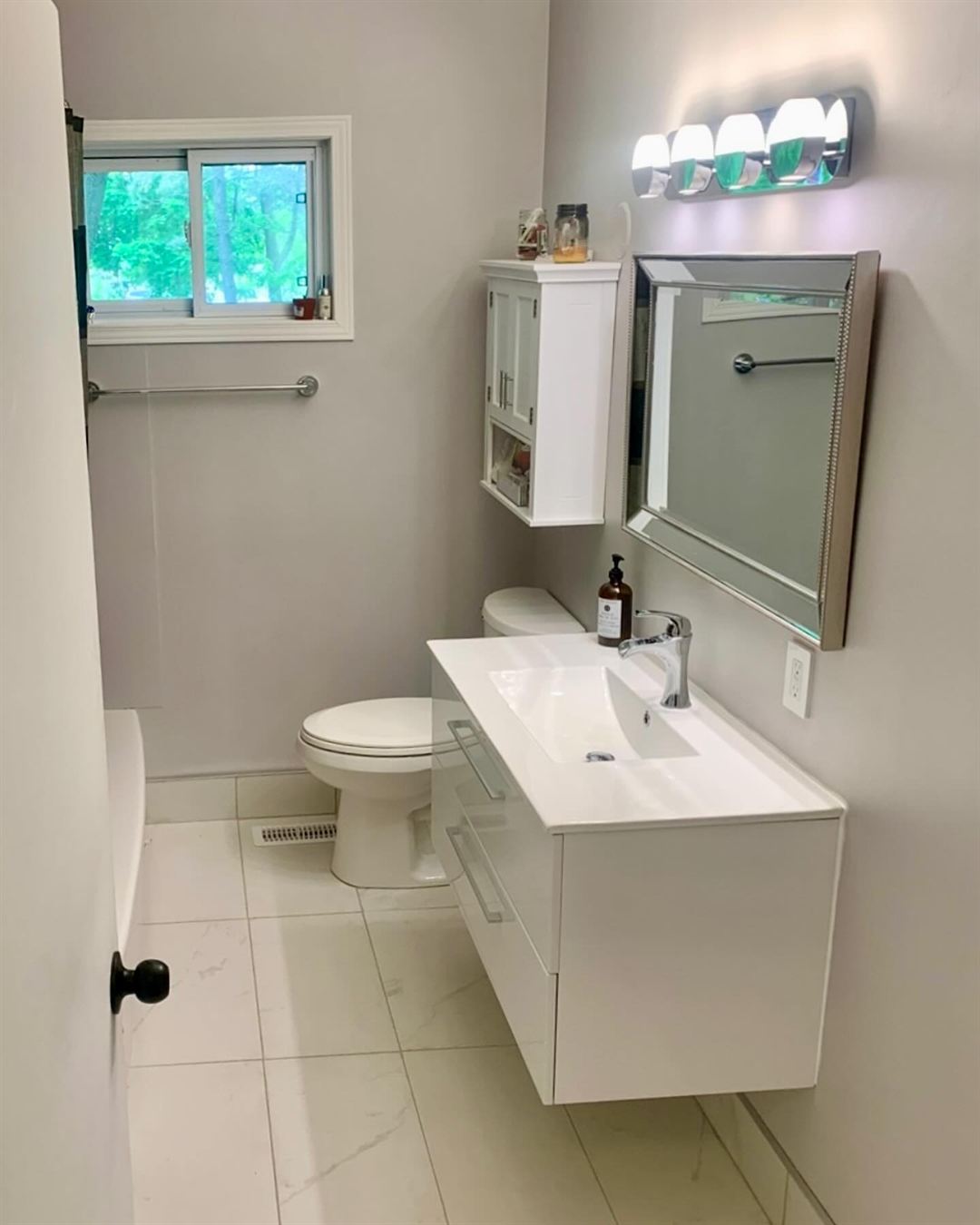 Finished bathroom with floating vanity and large-format tile
